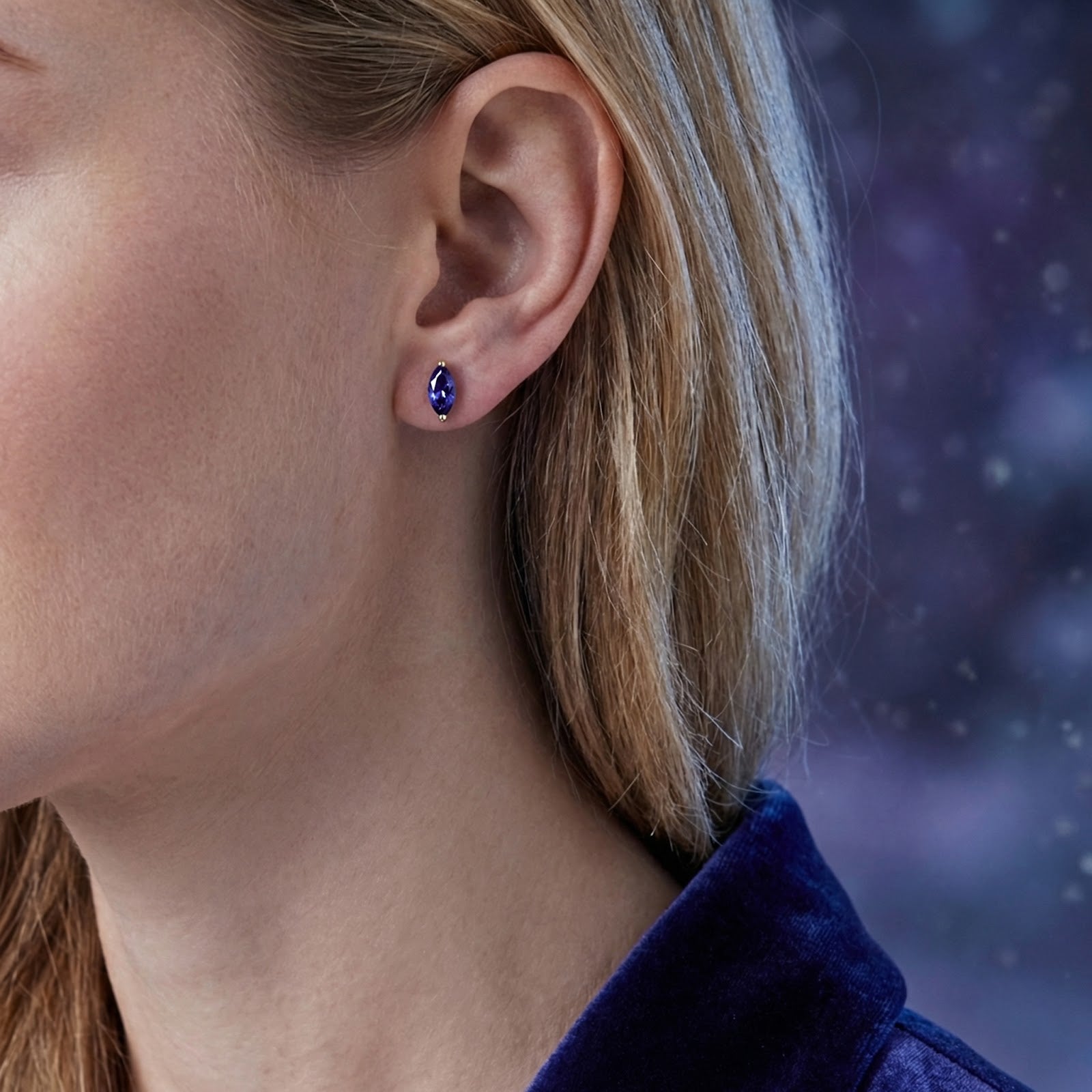 Model wearing a marquise-cut simulated tanzanite stud earring in 18K gold vermeil.
