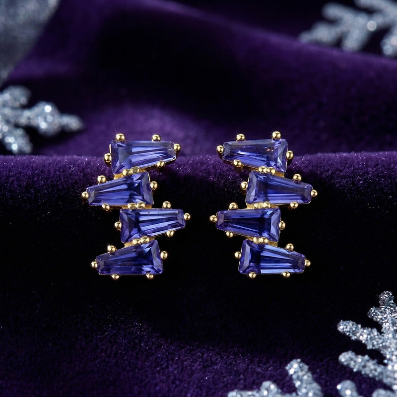 Front view of the 18K gold vermeil Neriselle cluster earrings with blue-violet simulated tanzanite on purple velvet.