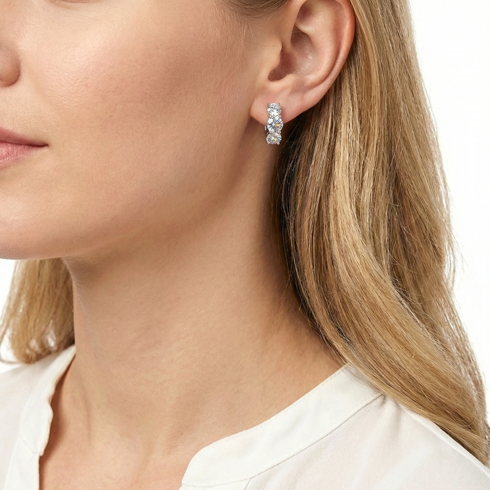 Model wearing the Calyssa trio huggie earrings in S925 sterling silver with three round-cut simulated diamonds.