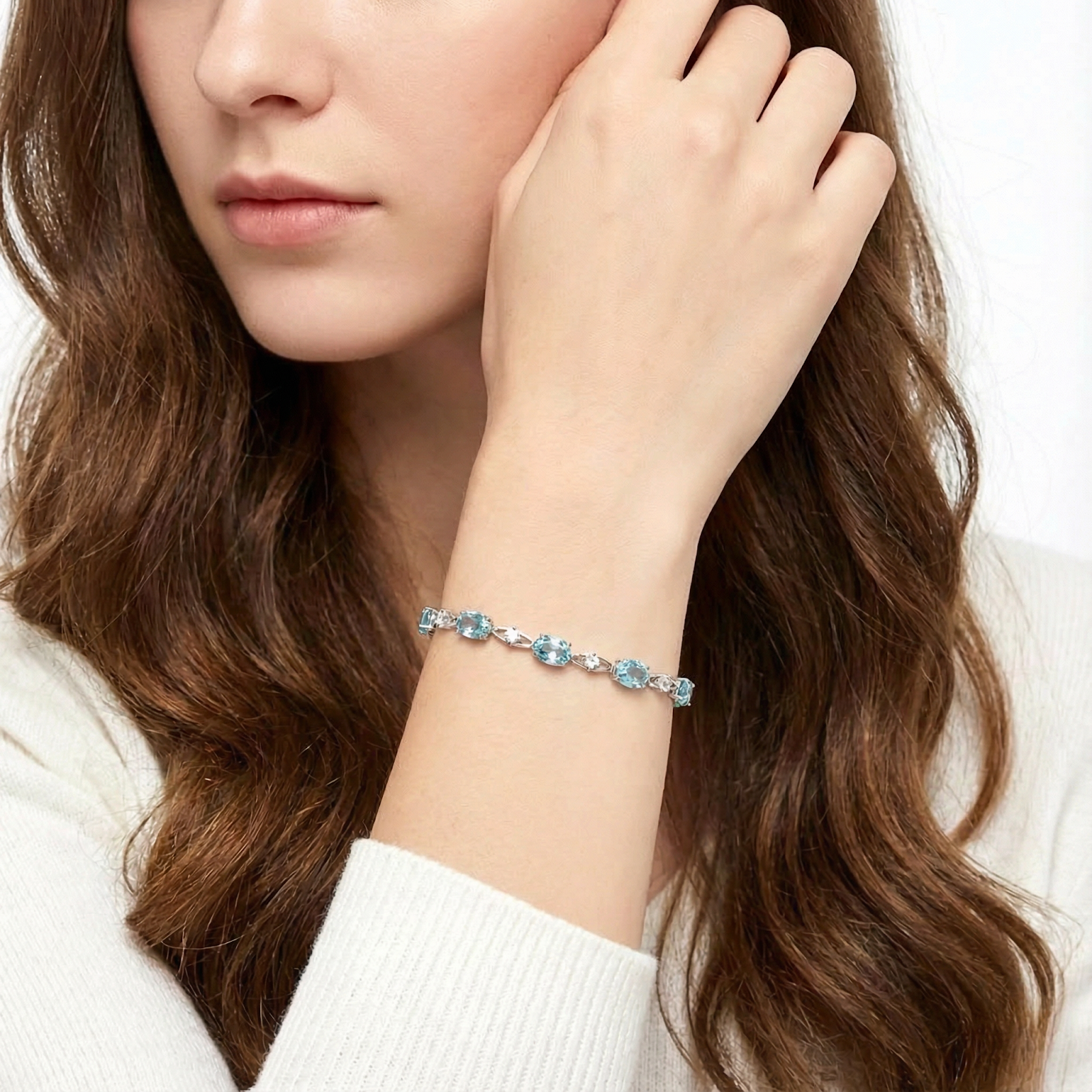 Model wearing the Azuria oval cut simulated aquamarine sterling silver bracelet on her wrist.