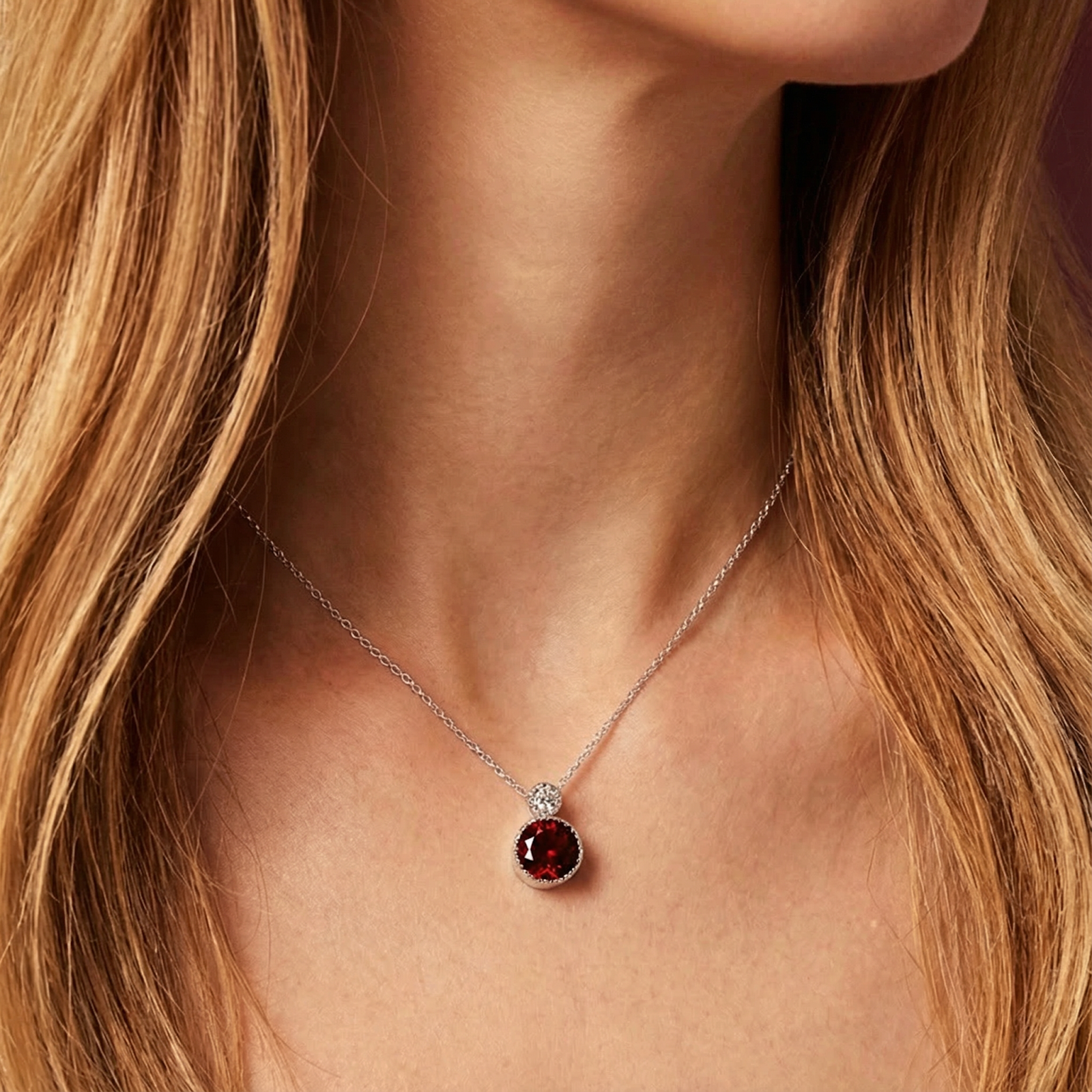 Close-up of a woman wearing the round red garnet drop necklace in 925 sterling silver.