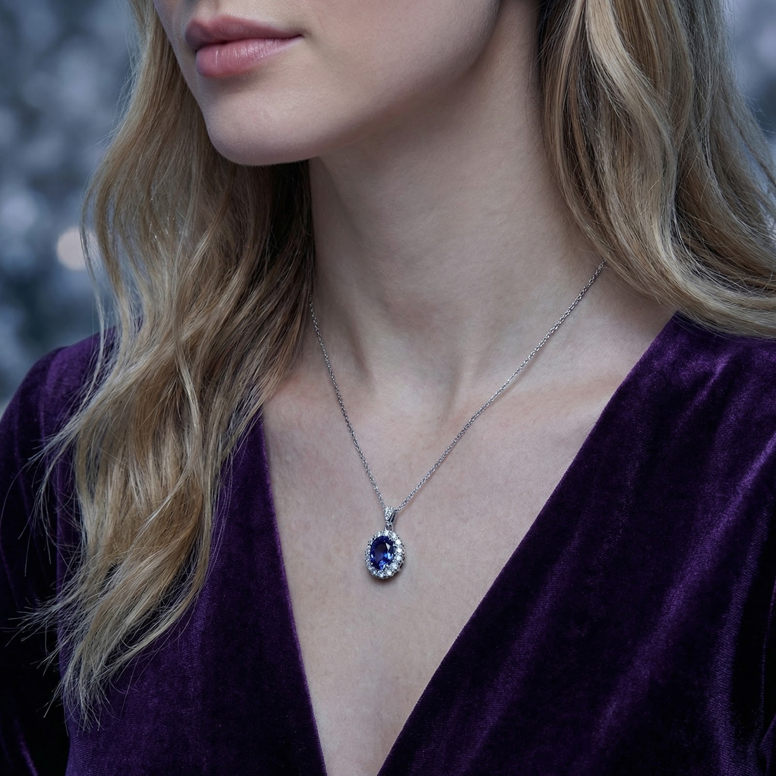 Side profile of a model wearing the sterling silver Azurienne halo necklace with a blue-violet simulated tanzanite.