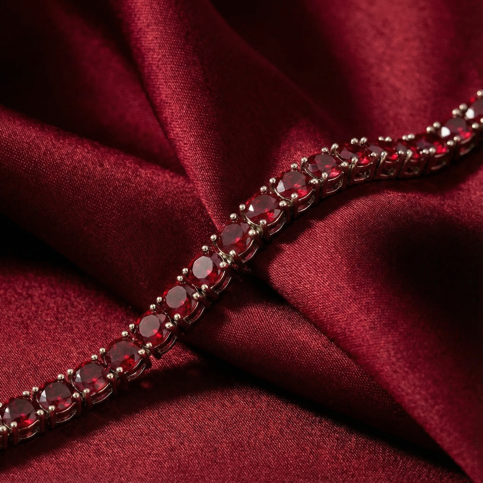 Macro shot of the Adalira bracelet's round-cut simulated rubies and silver-tone stainless steel prong setting.