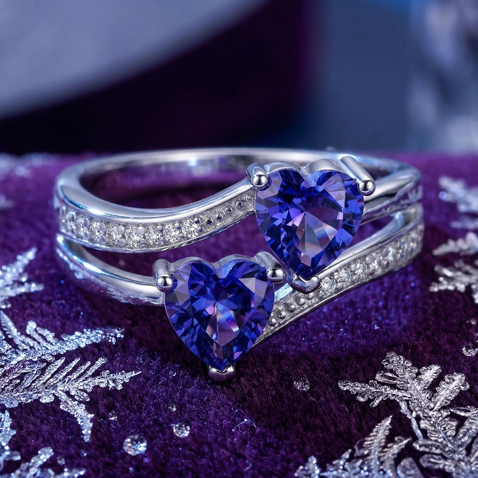 Front view of the S925 sterling silver heart bypass ring with blue heart-cut simulated tanzanite on purple velvet.