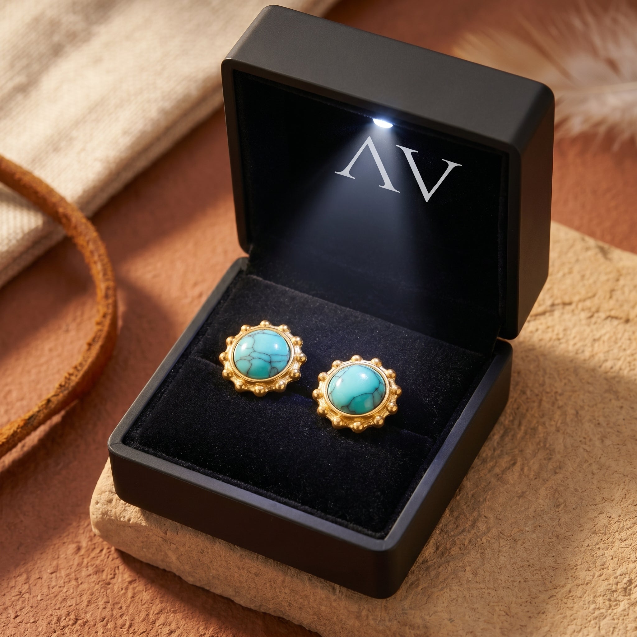 Gold turquoise cabochon stud earrings presented in a premium black lighted jewelry gift box.