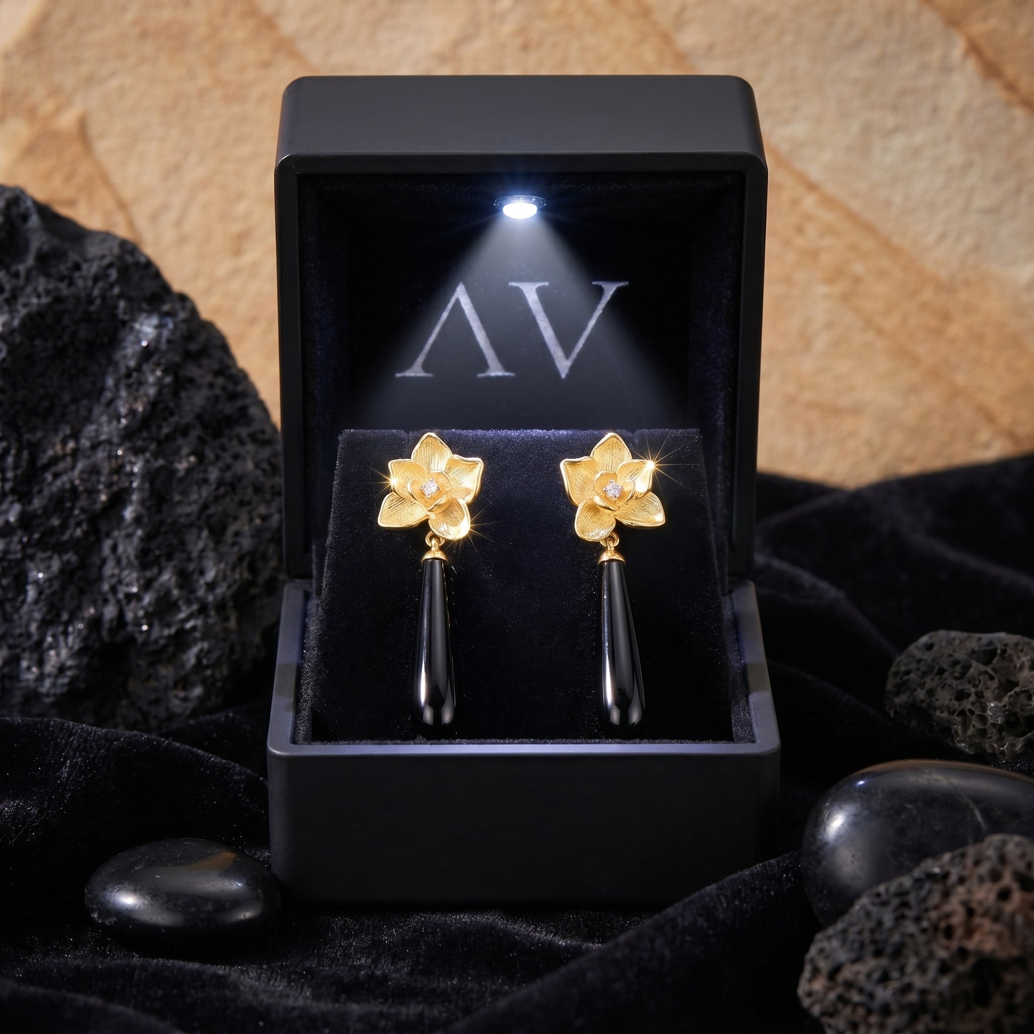 18K gold plated Calla floral black onyx drop earrings inside a black LED-lit jewelry gift box.
