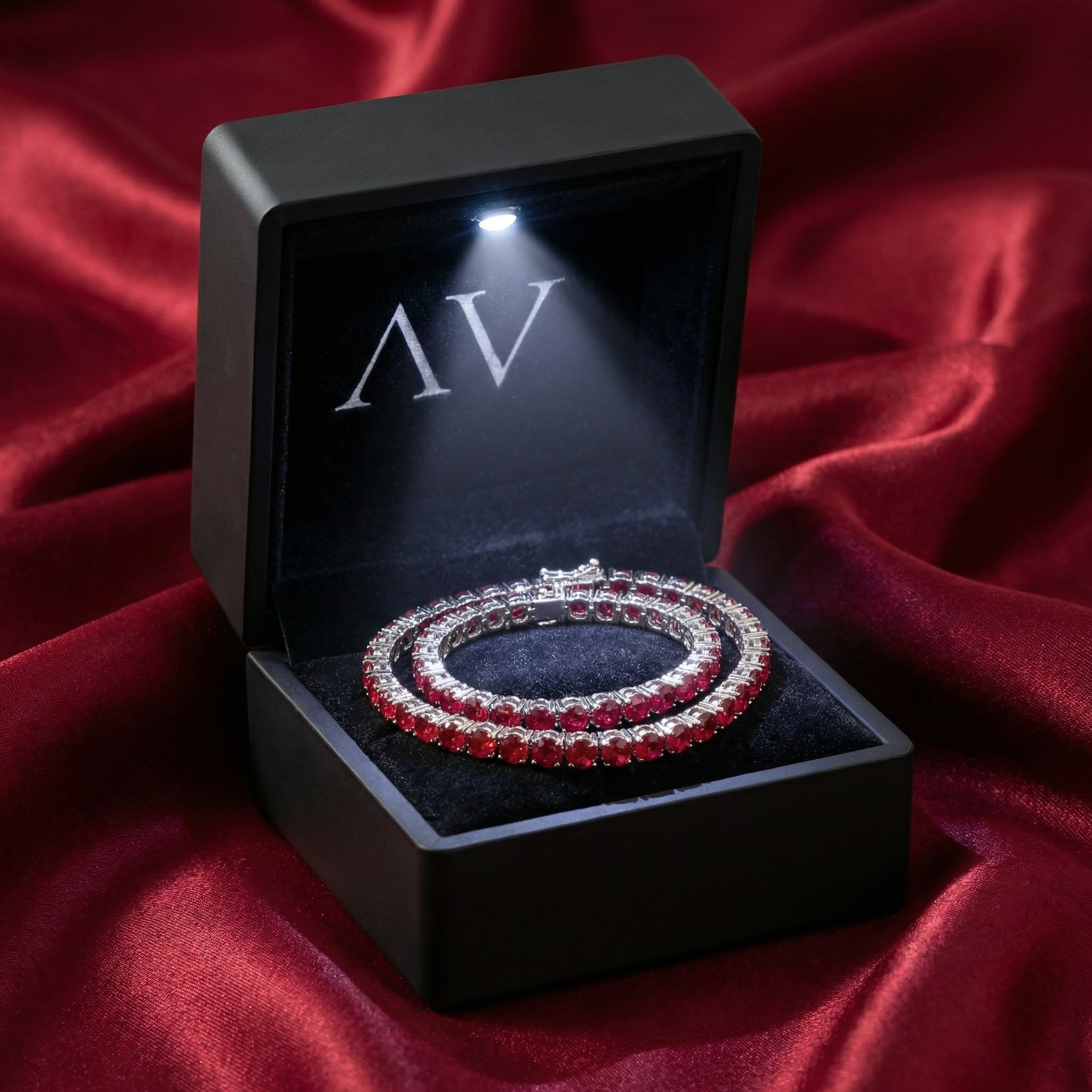 Adalira stainless steel tennis bracelet with red rubies in a premium black LED-lighted jewelry gift box.