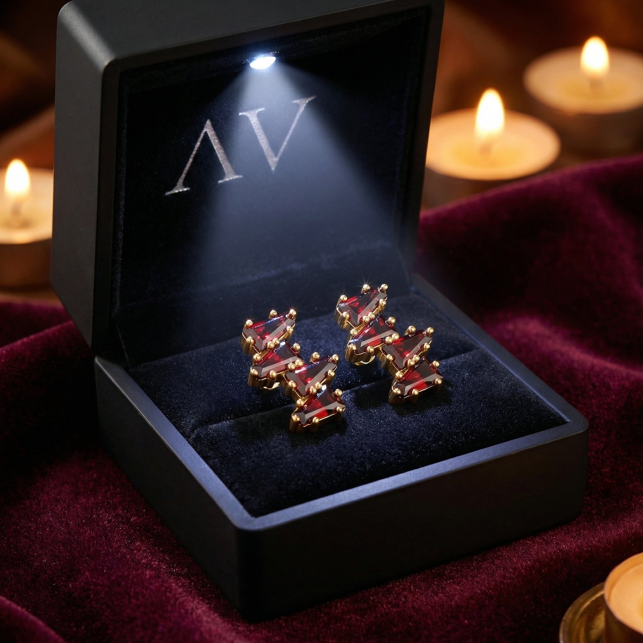 Red simulated garnet cluster earrings in 18K gold vermeil inside a black LED-lit jewelry box.