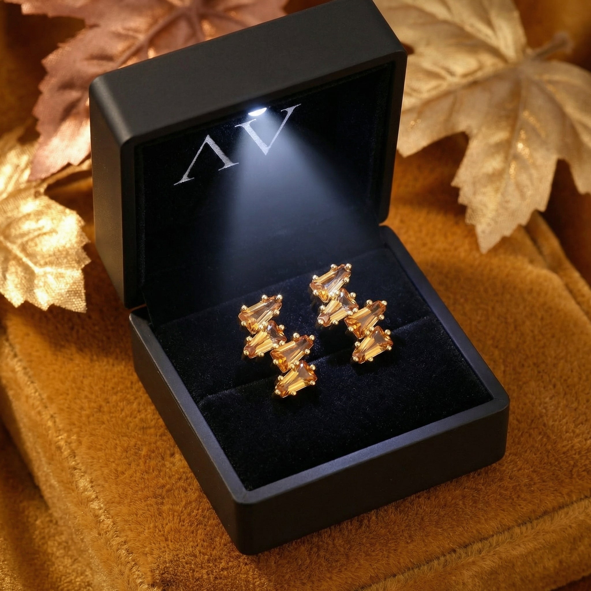 Lyranelle 18K gold vermeil cluster earrings with simulated topaz stones inside a black LED-lighted jewelry gift box.