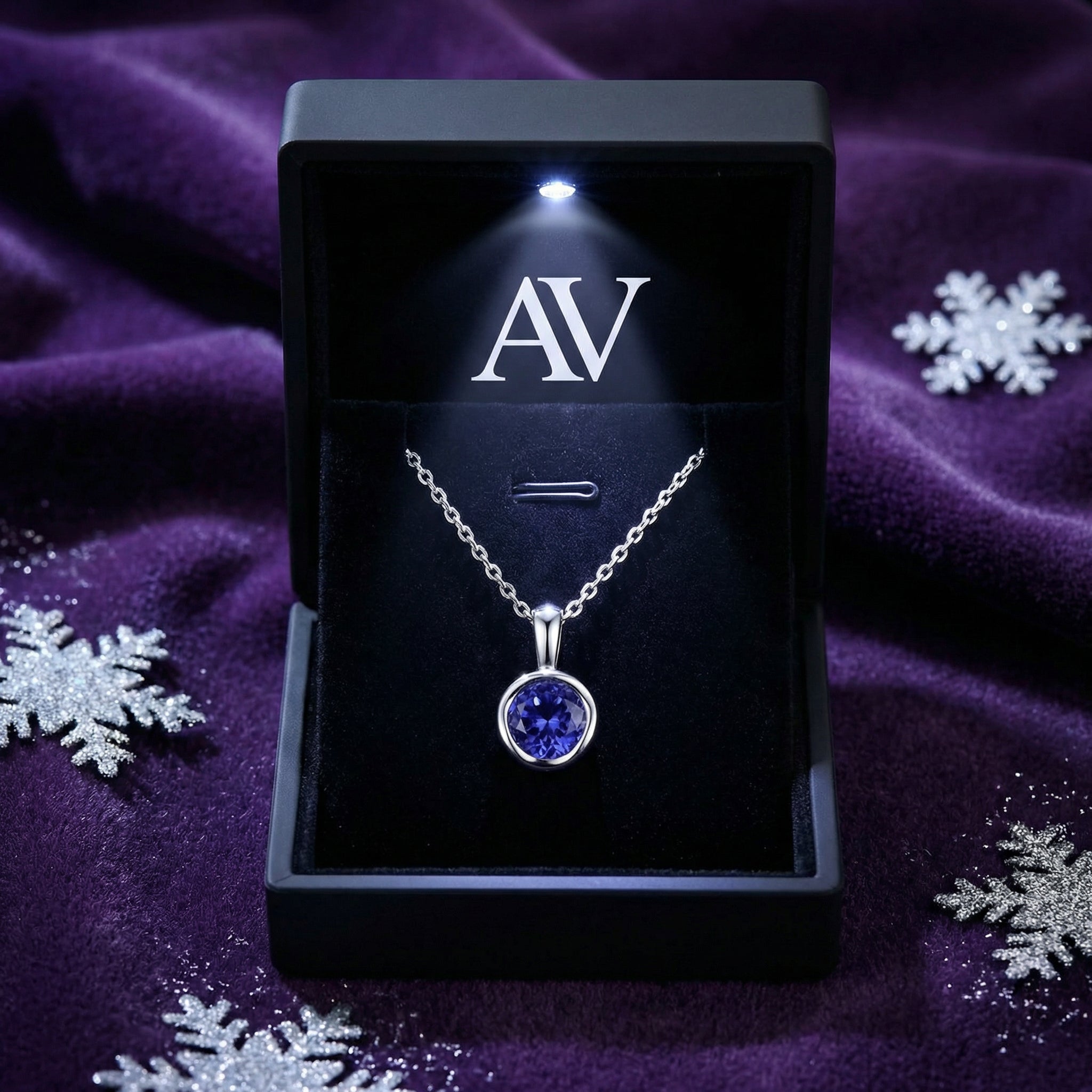 Simulated tanzanite silver necklace in a black LED-lighted jewelry box with snowflakes on purple velvet.