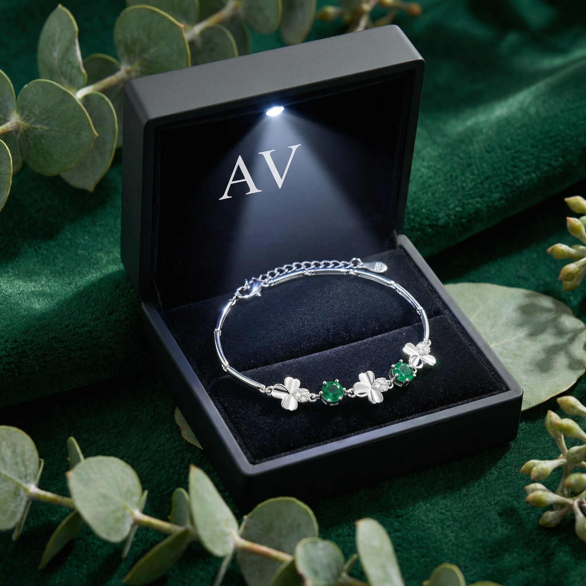 Sterling silver green emerald clover bracelet inside a black LED-lit gift box with the AV logo.