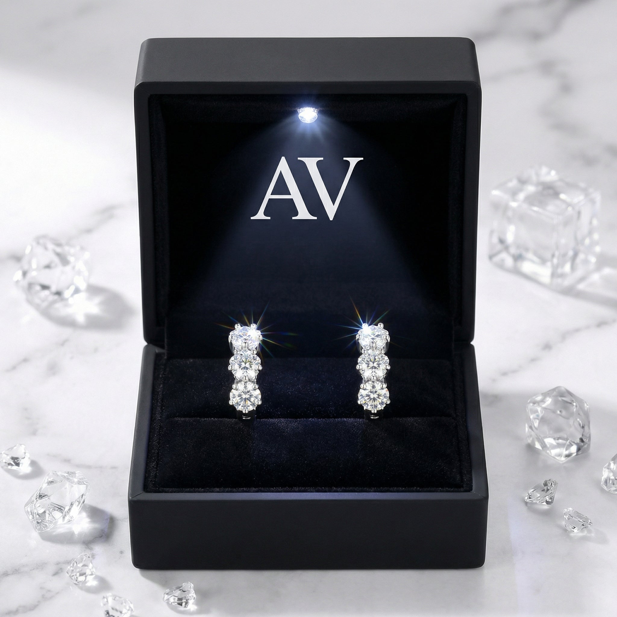 S925 sterling silver trio simulated diamond huggie earrings presented in a black LED-lit jewelry box.