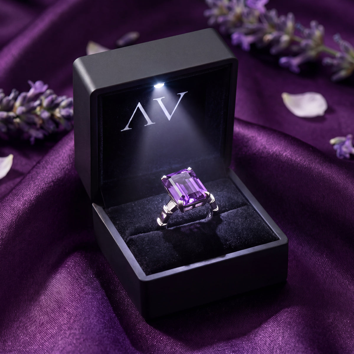 Emerald-cut violet amethyst ring presented in a black LED jewelry box.