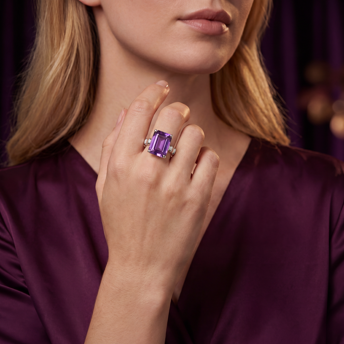 Emerald-cut violet amethyst ring worn on a model's hand to show its scale.
