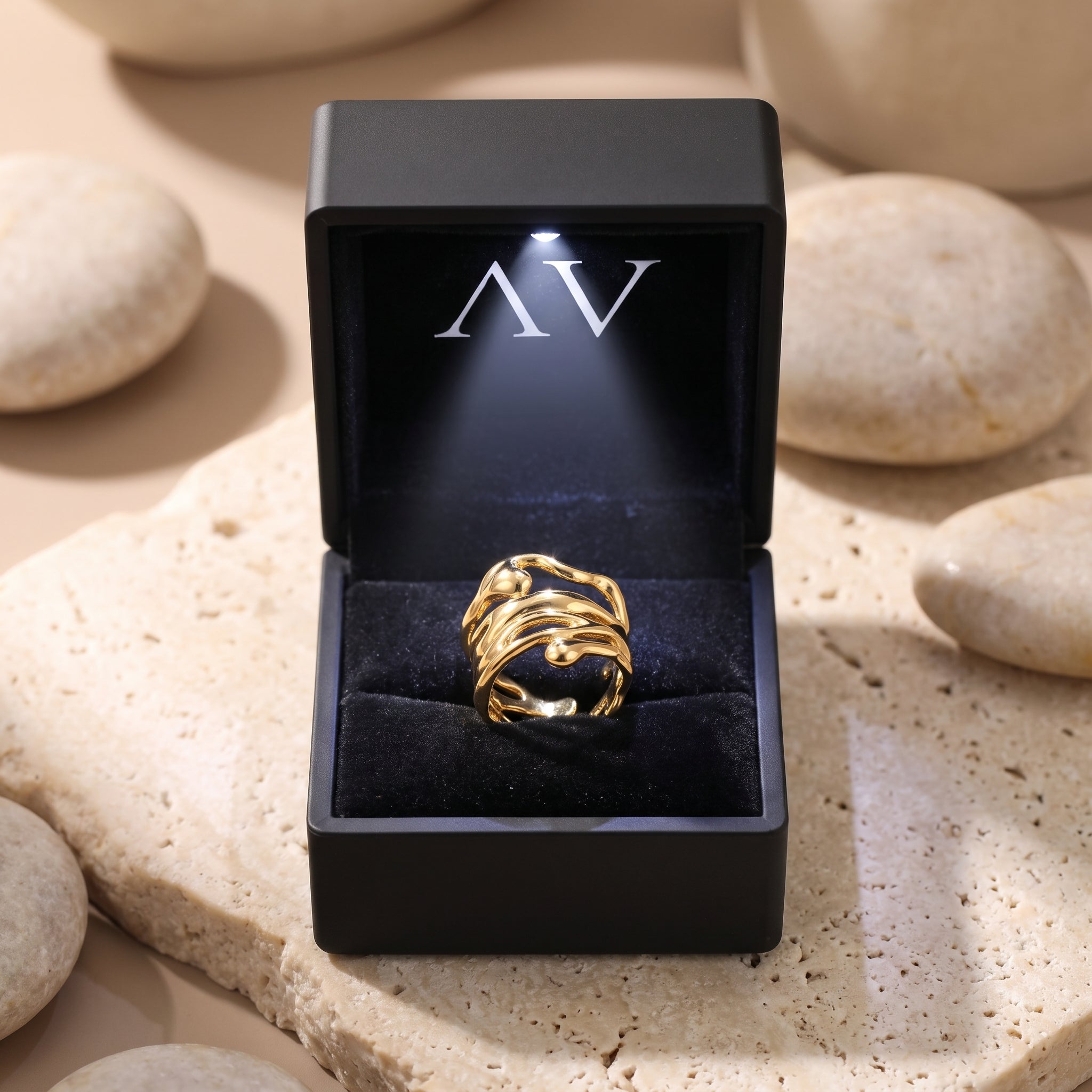 Gold Marinella ring presented in a black LED-lit jewelry box.