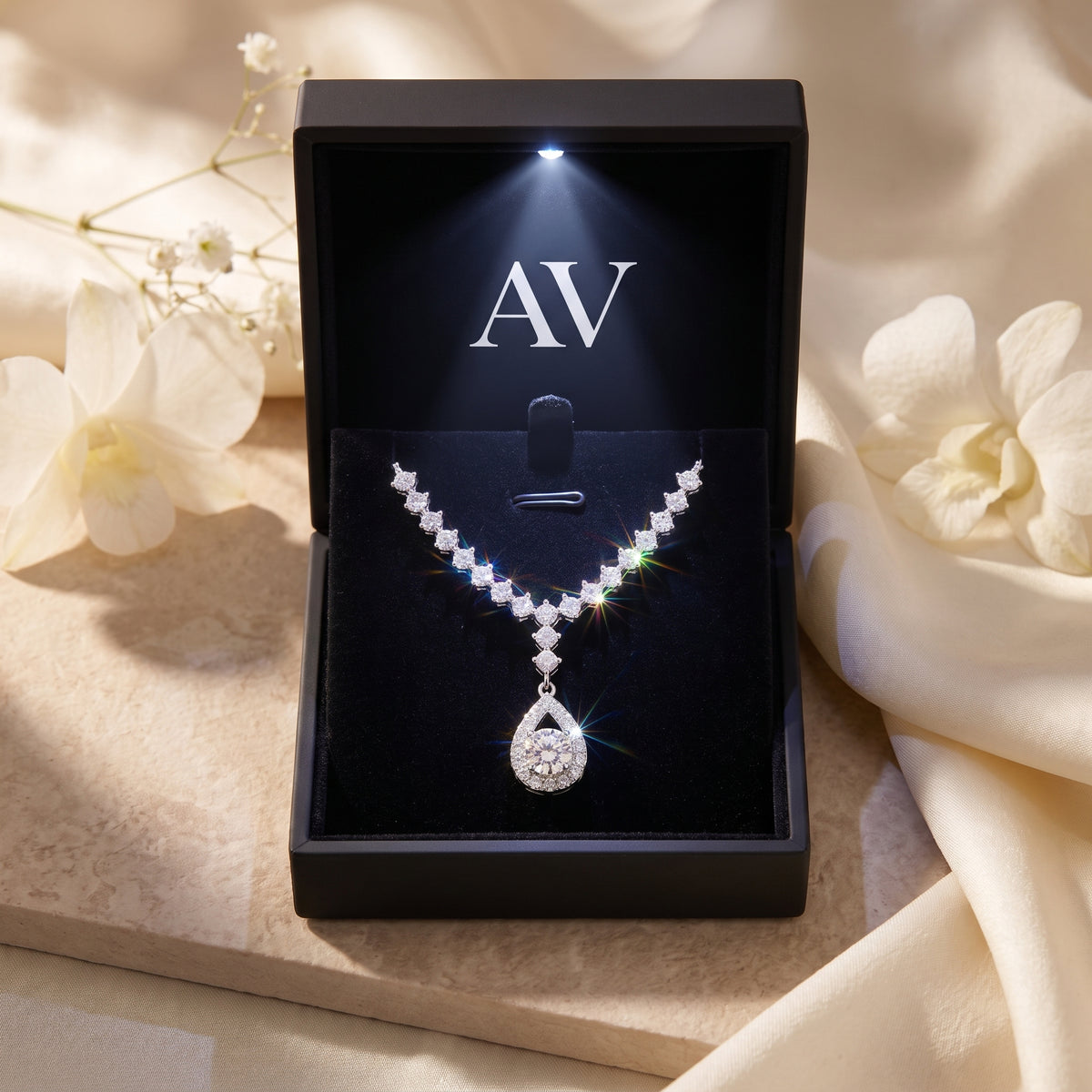 Silver moissanite necklace displayed in a black LED-lit gift box with AV logo.