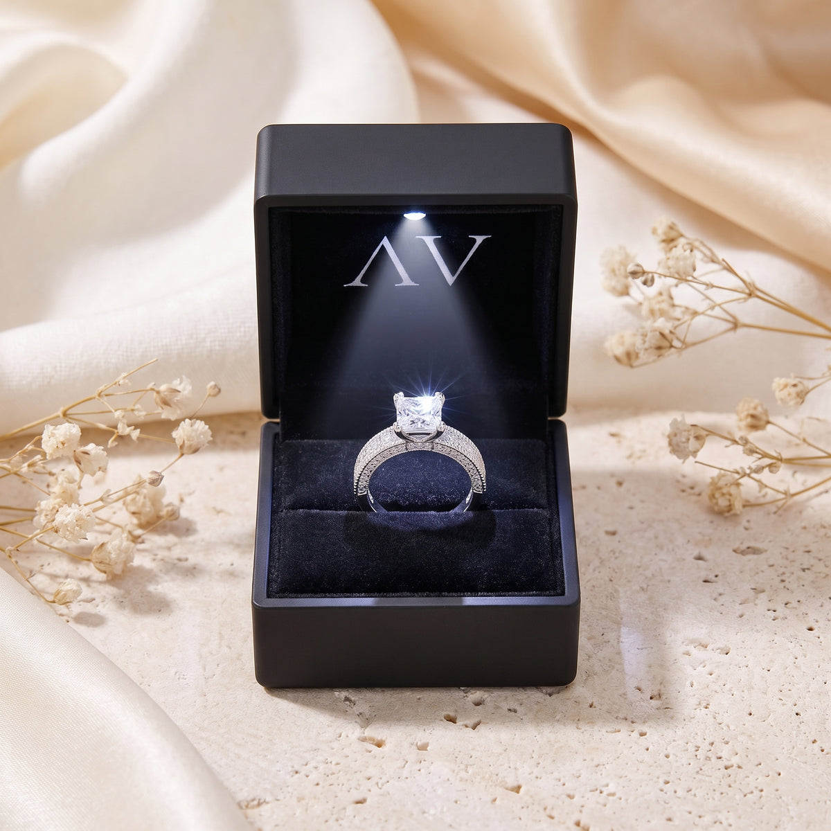Princess cut CZ silver ring in LED-lit black gift box.