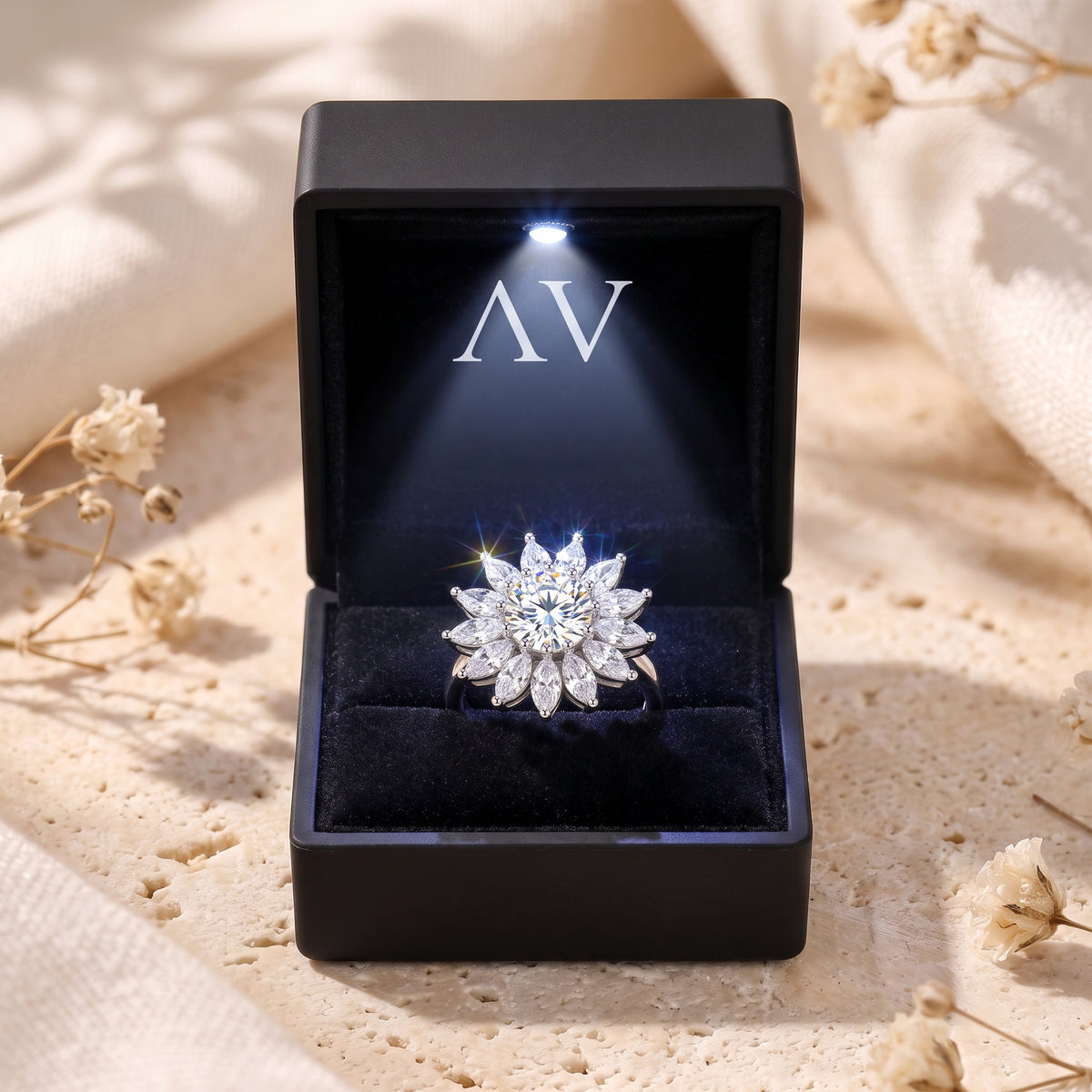 Silver sunburst halo ring presented in a black lighted jewelry box with a velvet interior.