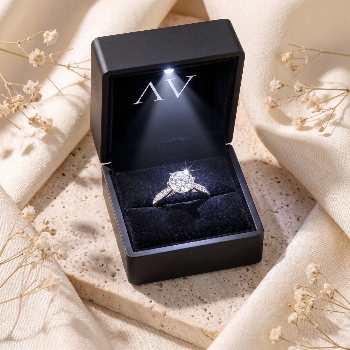 Silver solitaire ring in a black LED-lighted jewelry gift box.