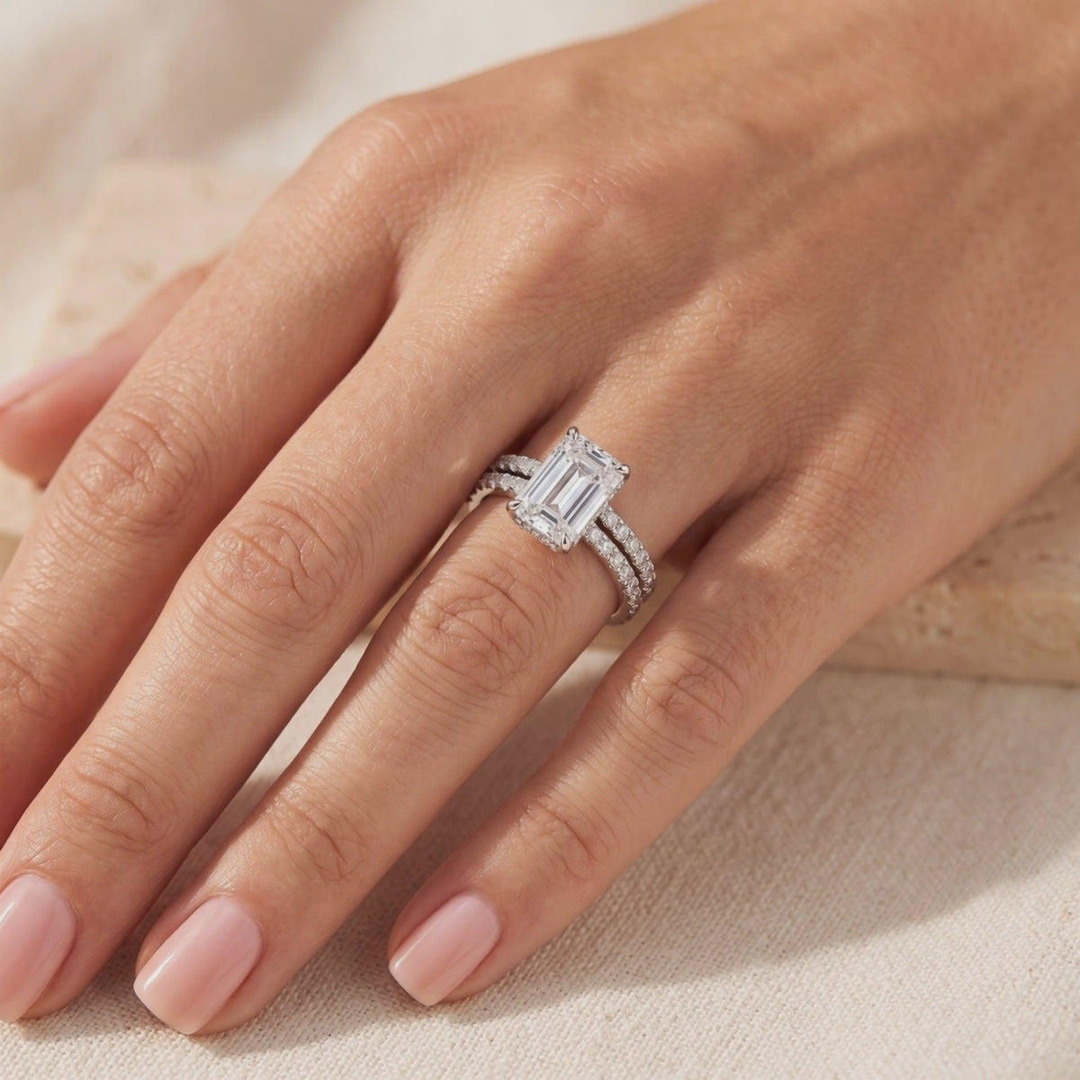 Silver ring set worn on hand, featuring an emerald-cut stone on a pavé band with a matching eternity ring.