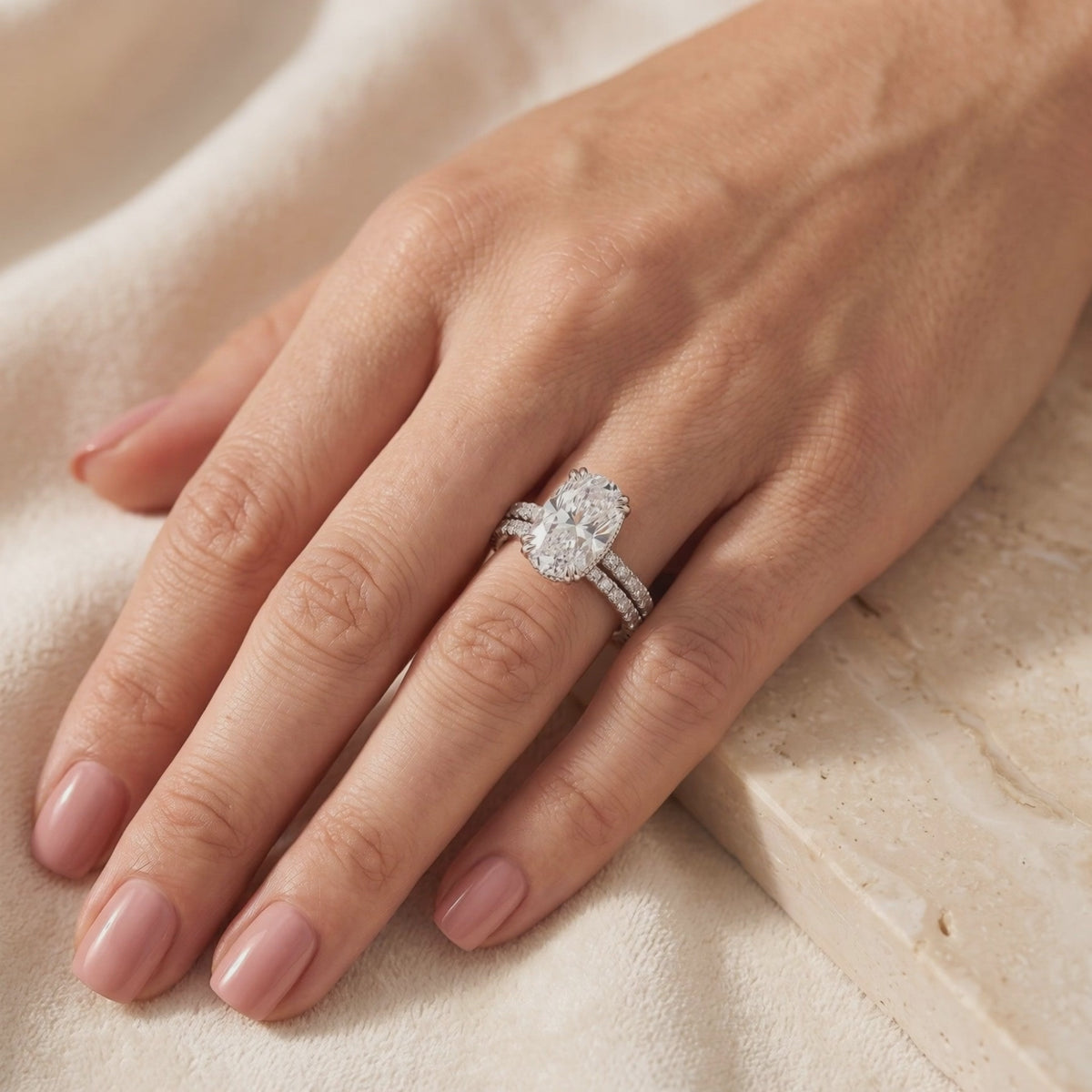 Oval center ring with a matching pavé band worn together on a hand