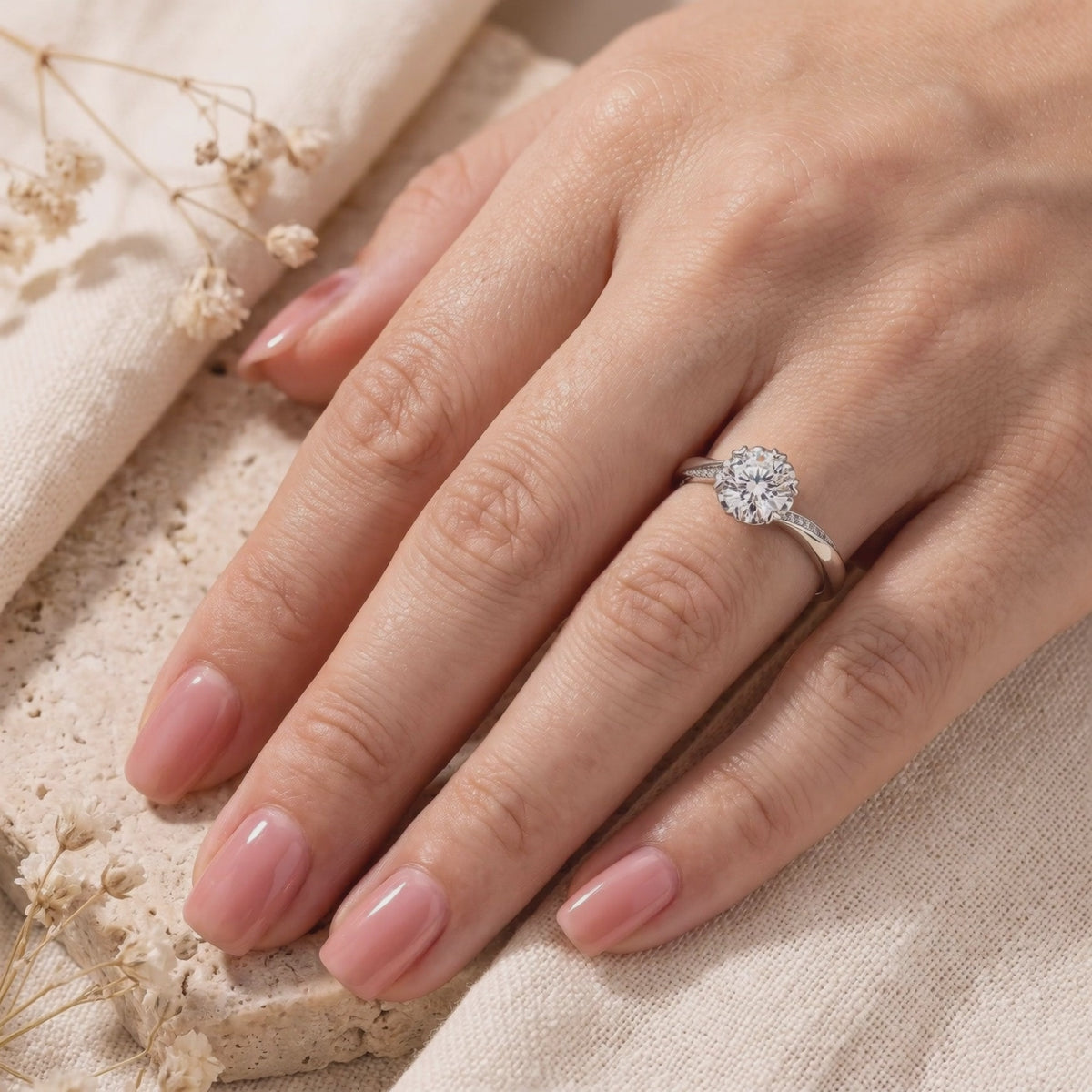 Silver Liorabelle promise ring with a round clear center stone, worn on a manicured hand.