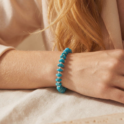 Turquoise disc-bead bracelet with silver spacers shown worn around a wrist