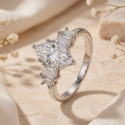 Close-up view of the silver Melanthe Ring with a marquise clear center stone and baguette side accents.