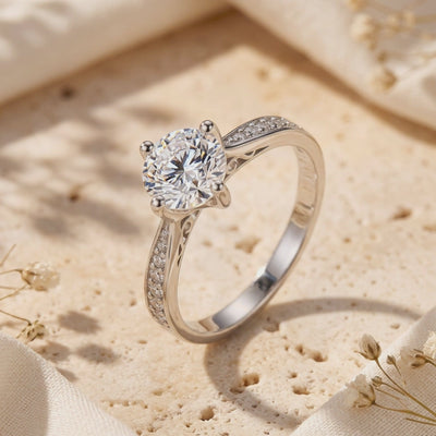 Close-up of a silver micro-pavé solitaire ring standing on a textured stone surface.