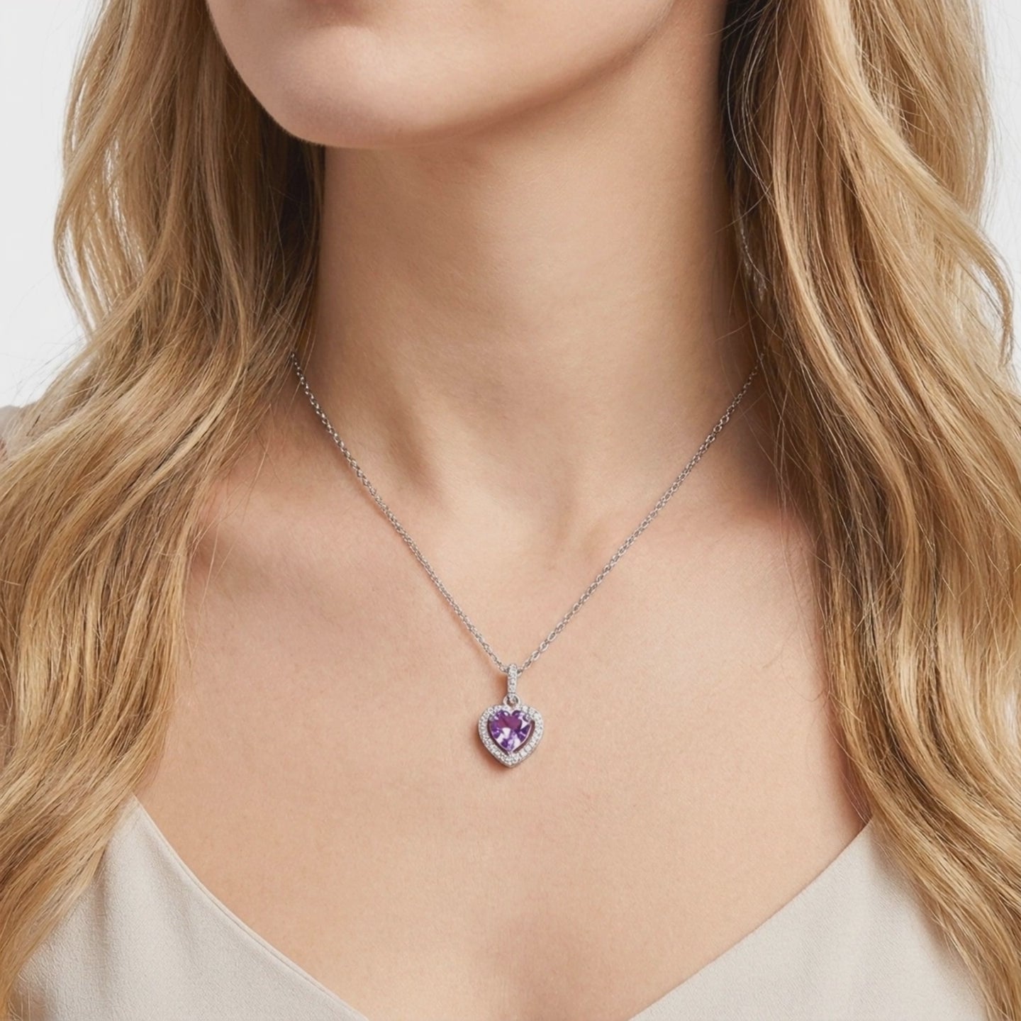 A solid gold pendant necklace with a simulated amethyst.
