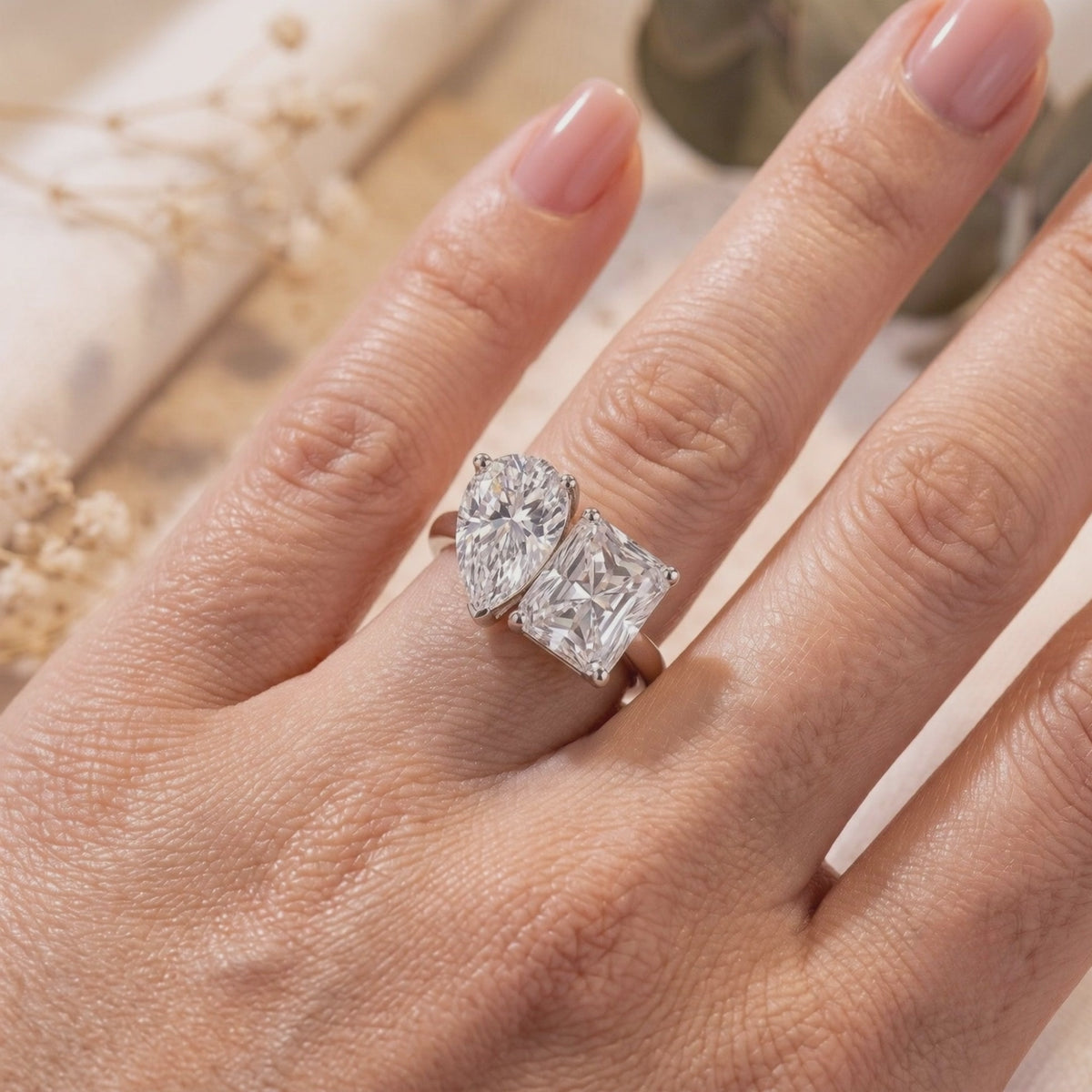 Silver Corentine Toi et Moi ring with pear- and radiant-cut stones worn on a finger