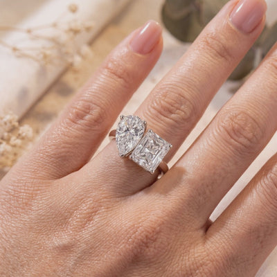 Silver Corentine Toi et Moi ring with pear- and radiant-cut stones worn on a finger