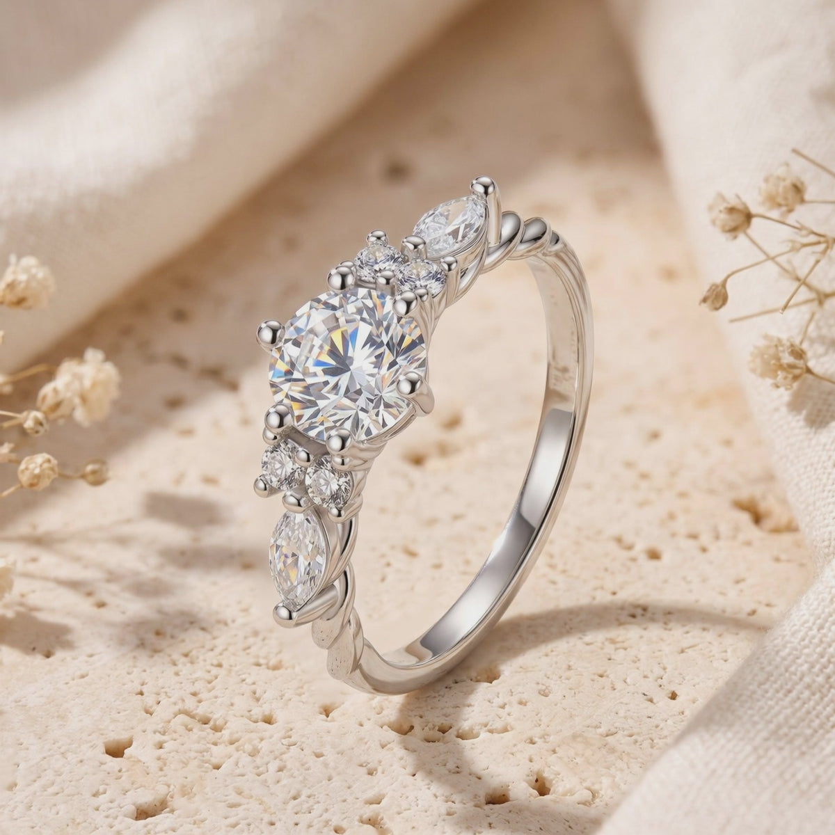 Close-up of the silver vintage-style Carlotta ring with round and marquise stones standing on a textured surface.