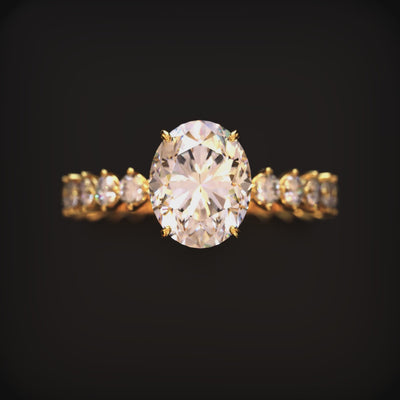 Solid gold ring with an oval center stone and shared-prong stones along the band.