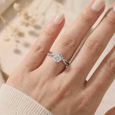Round moissanite crown ring in sterling silver worn on a finger, shown from an angled close-up view.