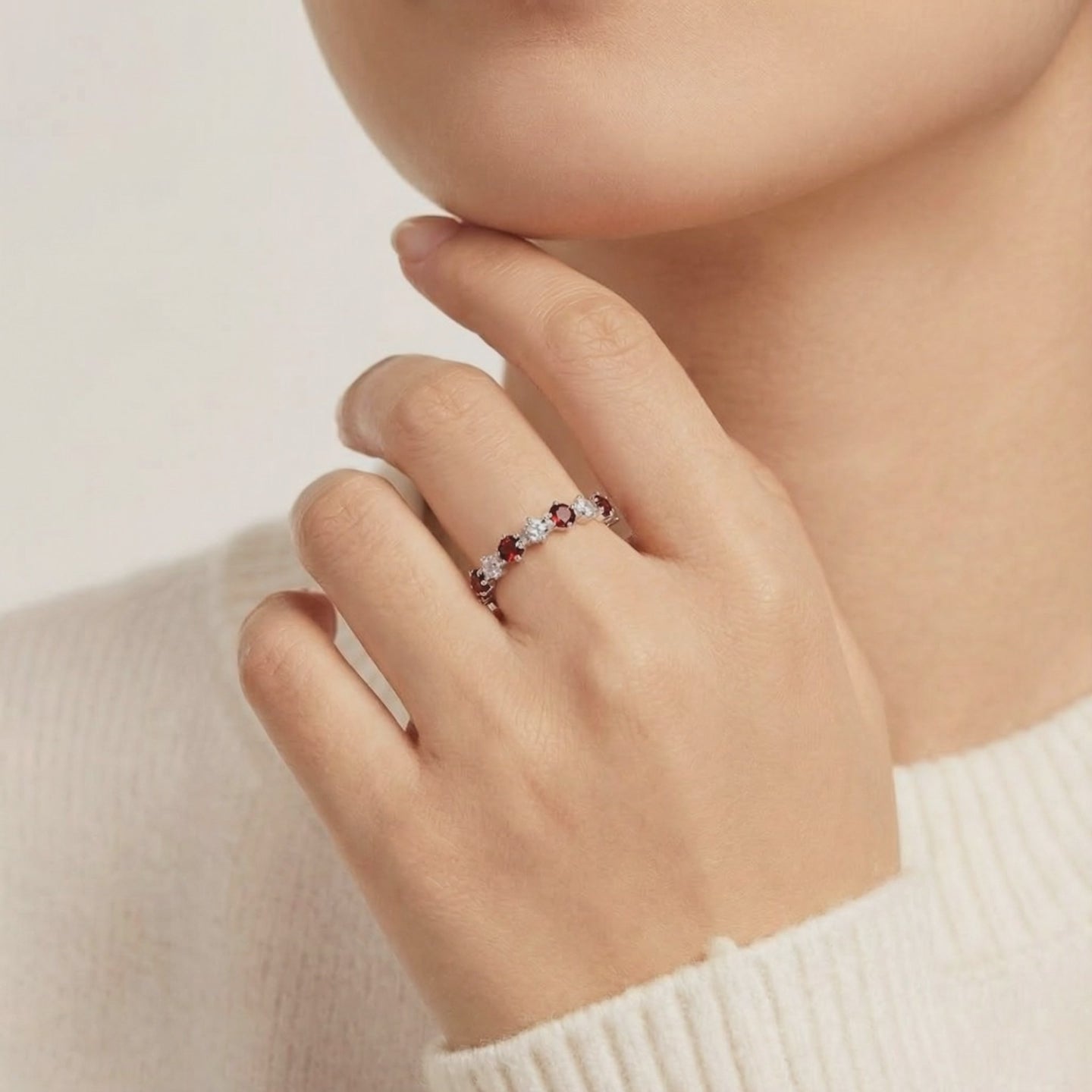 A solid gold eternity ring with simulated garnets.