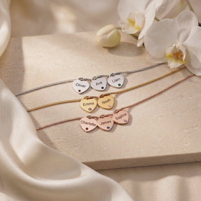 Three personalized heart necklaces displayed flat in silver-, gold-, and rose-gold tones with colored stones.