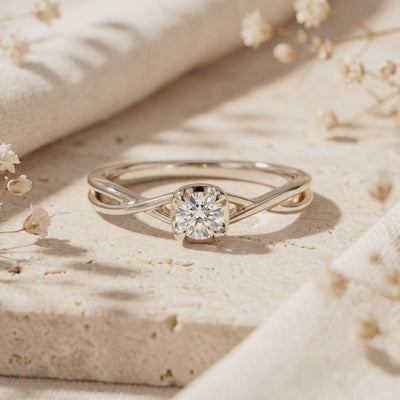 Silver-toned Calydonia ring featuring a round-cut stone and twisted band displayed on a stone surface.