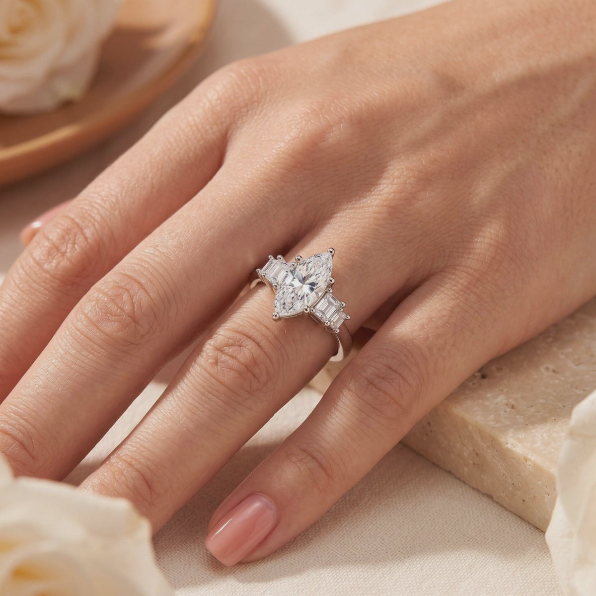 The silver Melanthe Ring with a marquise clear center stone and baguette side accents, worn on a hand.