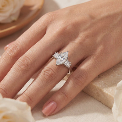 The silver Melanthe Ring with a marquise clear center stone and baguette side accents, worn on a hand.