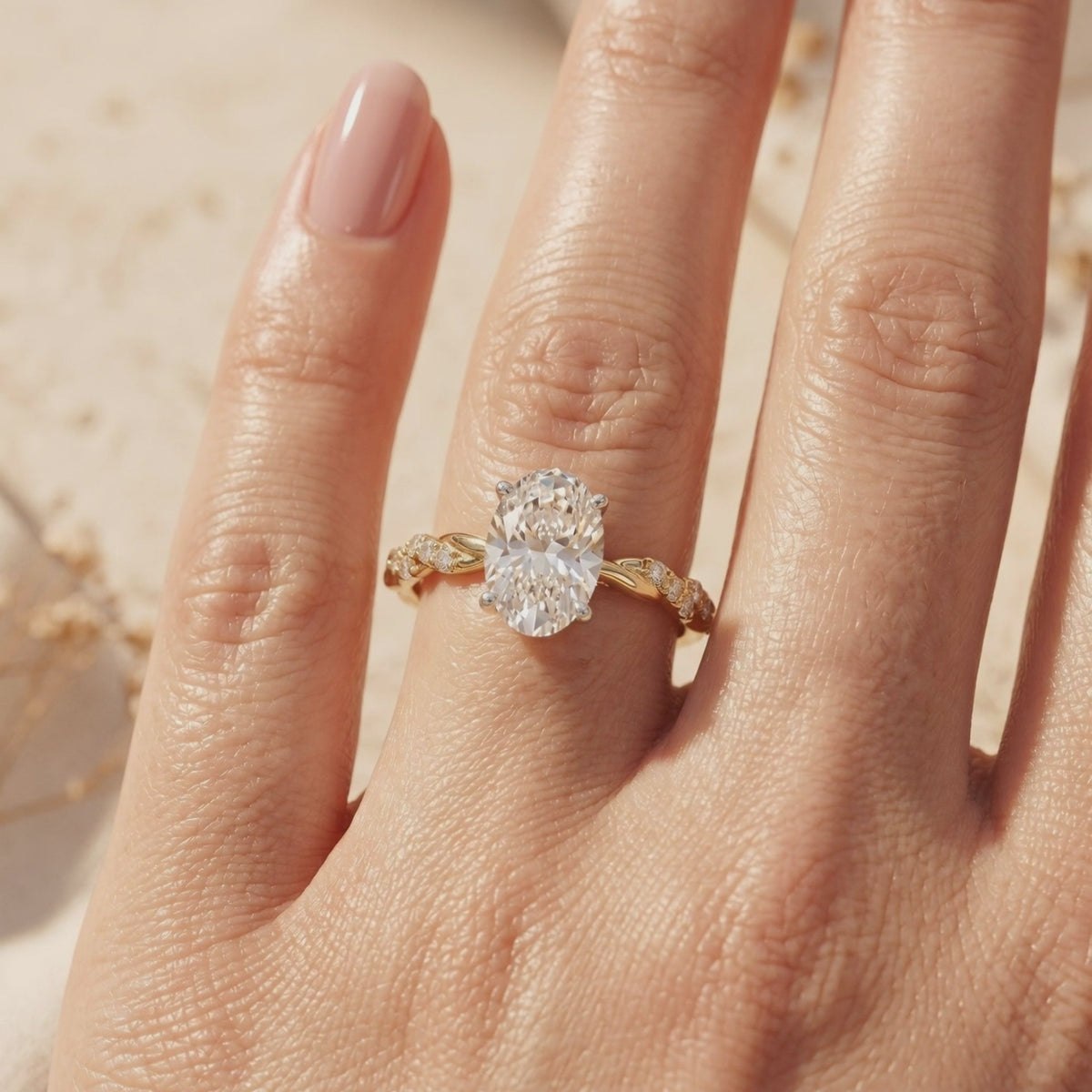 Gold-toned Lysandrielle ring with an oval center stone and twisted pavé band worn on a hand.
