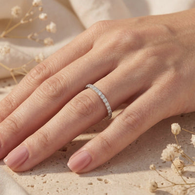 Video preview of a slim silver pave ring with round moissanite stones worn on a hand.