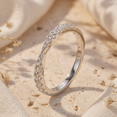 Close-up of the silver contoured wave ring showing pavé-set stones and an S925 inner-band stamp.