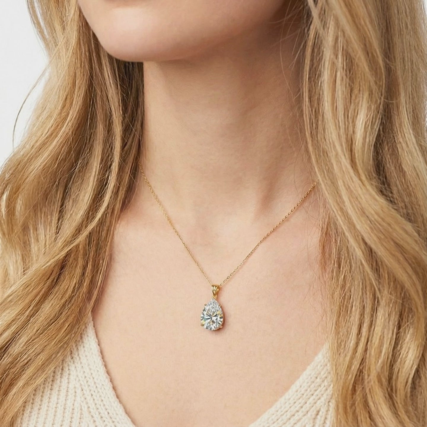 A solid gold necklace with a pear-cut A5 Zirconia pendant.