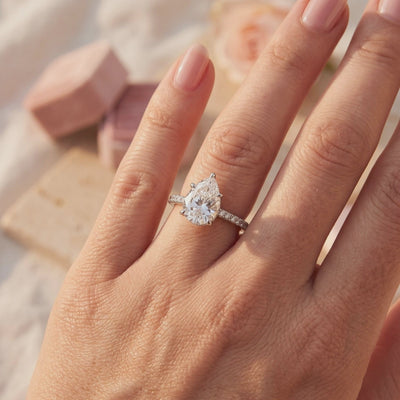 Pear-cut silver Dianora ring with pavé band worn on a hand in warm sunlight.