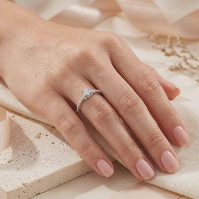 The Josephine silver ring with a round clear center stone and pavé band worn on a hand's ring finger.