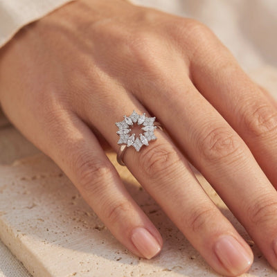Silver Stellaire ring with an open starburst of clear marquise and round stones, shown worn on a hand.