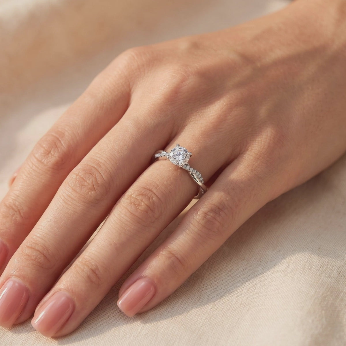 The Sylviette silver ring with a round clear stone and twisted pavé band, shown worn on a hand.