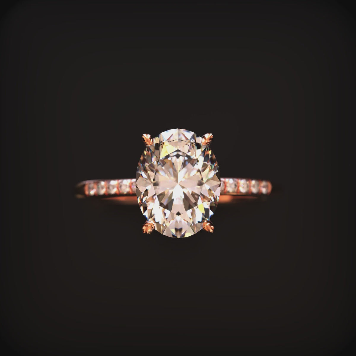 An oval moissanite ring in solid gold with a pavé band.