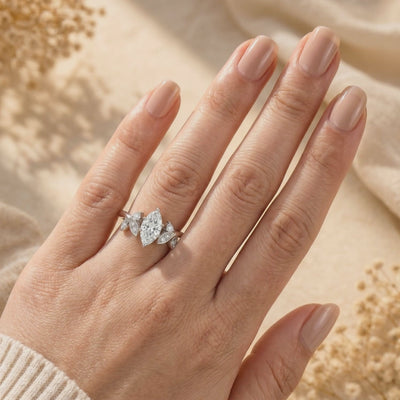 Hand wearing a silver marquise-cut moissanite ring with leaf-shaped side accents